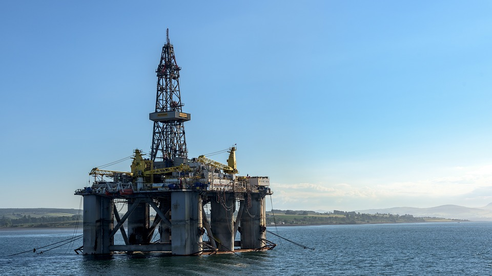 An oil rig at sea near a shore