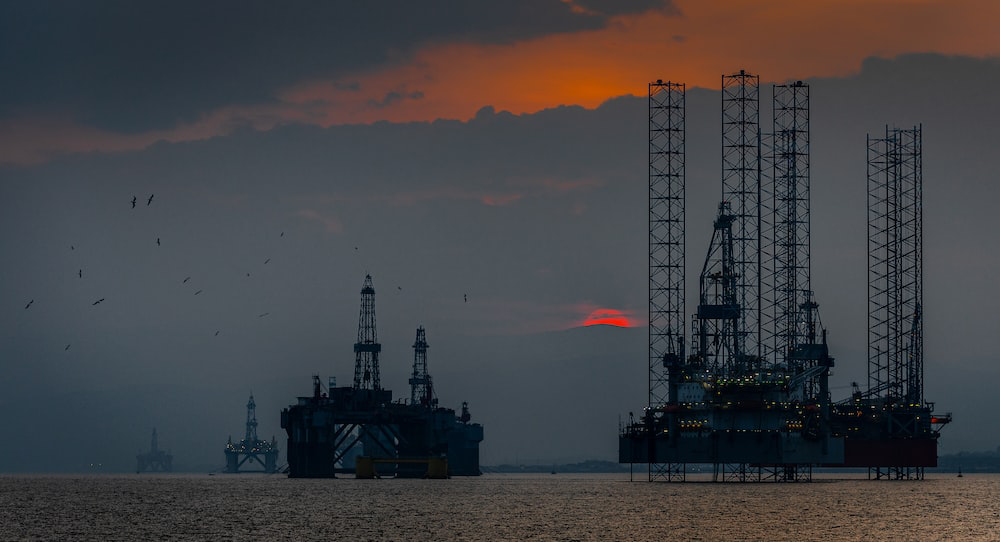 Onshore oil rigs with the sun setting in the background